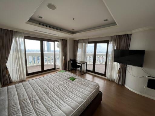 Spacious bedroom with large windows and a balcony