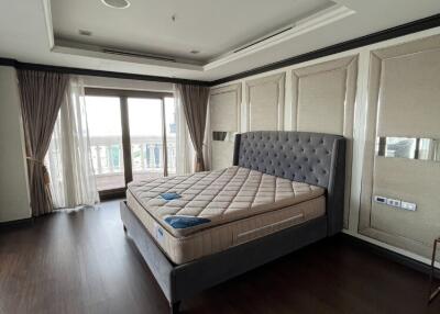 Spacious bedroom with large windows and bed