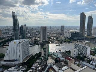 High-rise buildings along a river with a cloudy sky