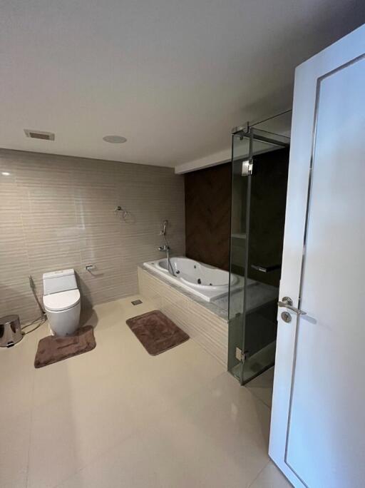 Modern bathroom with toilet, bathtub, and glass shower