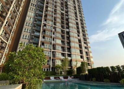 View of a high-rise apartment building with a swimming pool in the foreground.