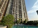 View of a high-rise apartment building with a swimming pool in the foreground.