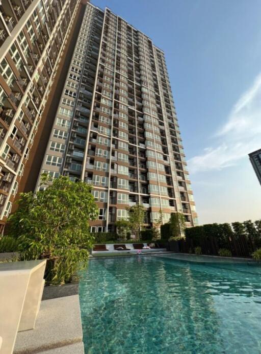 View of a high-rise apartment building with a swimming pool in the foreground.