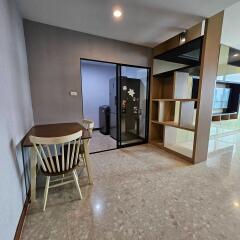 Dining area with a wooden table and chairs adjacent to a sliding glass door leading to another room