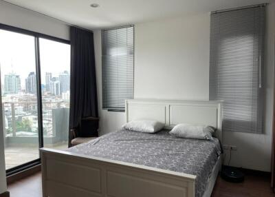 Modern bedroom with large windows and city view