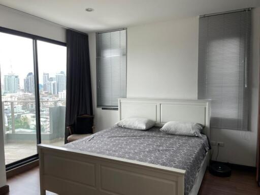 Modern bedroom with large windows and city view