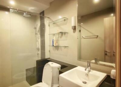 Modern bathroom with glass shower, toilet, and sink