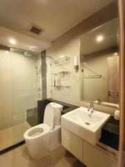 Modern bathroom with glass shower, toilet, and sink