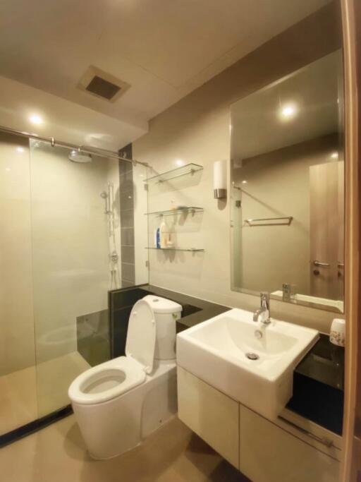 Modern bathroom with glass shower, toilet, and sink