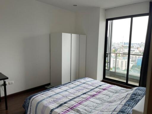 Bedroom with bed, wardrobe, window with city view