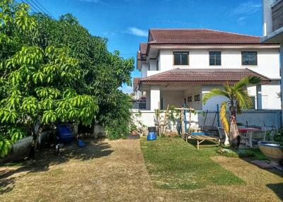 Backyard view of a house with garden and trees