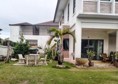 Exterior view of a house with a lawn and outdoor furniture