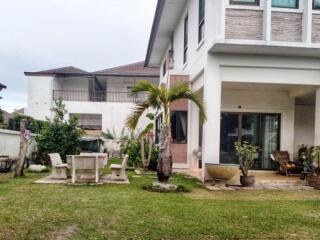 Exterior view of a house with a lawn and outdoor furniture