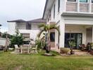 Exterior view of a house with a lawn and outdoor furniture