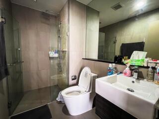 Modern bathroom with glass-enclosed shower, toilet, and sink
