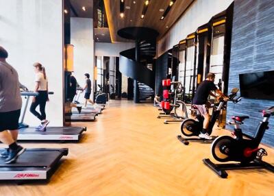 Modern gym with various exercise equipment and a spiral staircase