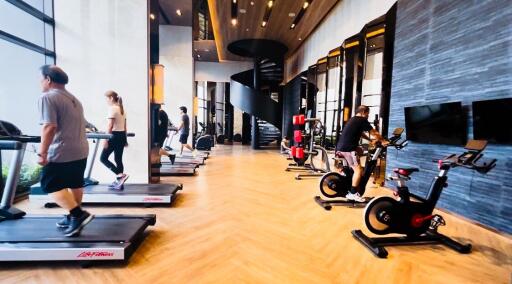 Modern gym with various exercise equipment and a spiral staircase