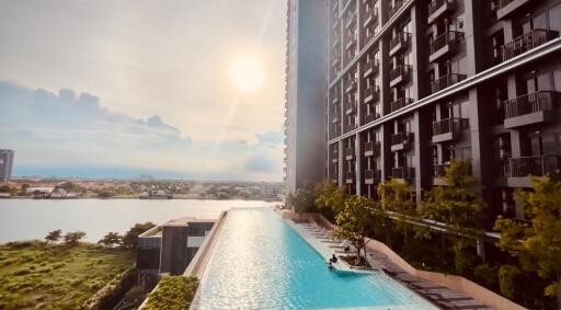 Modern high-rise apartment building with a swimming pool and city view