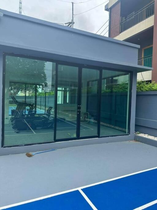 Outdoor view of a modern house gym with glass sliding doors