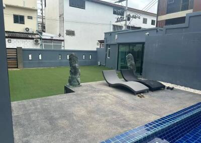 Outdoor area with lounge chairs, statues, and artificial grass