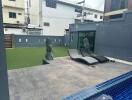Outdoor area with lounge chairs, statues, and artificial grass