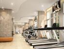 Modern gym with various exercise equipment including treadmills and elliptical machines