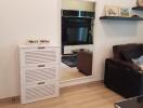 Modern living room with a sofa, wall-mounted shelves, a mirror, and a cabinet.