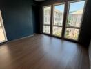 Unfurnished bedroom with large windows and wooden floor