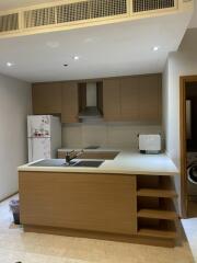 Modern kitchen with island, sink, stove, cabinets, fridge, and microwave.