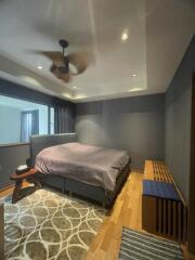 Modern bedroom with ceiling fan and large window