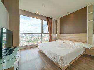 Spacious bedroom with large window and modern furnishings