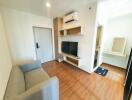 Modern living room with sofa, wall-mounted shelves, television, and air conditioner