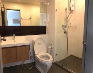 Modern bathroom with glass-enclosed shower, toilet, and sink