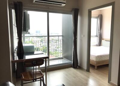 Main living area with balcony access and adjacent bedroom