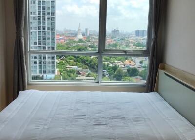 Bedroom with a large window and city view