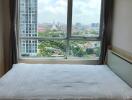 Bedroom with a large window and city view