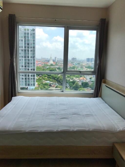 Bedroom with a large window and city view