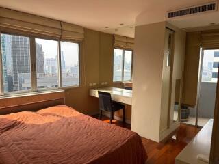 Bedroom with large windows and city view