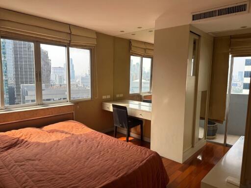 Bedroom with large windows and city view