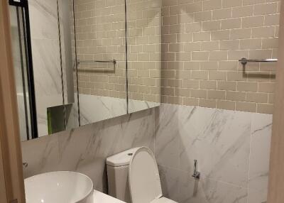 Modern clean bathroom with large mirror, toilet, and sink