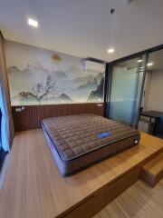 Modern bedroom with large window, elevated platform bed, and artistic wall mural