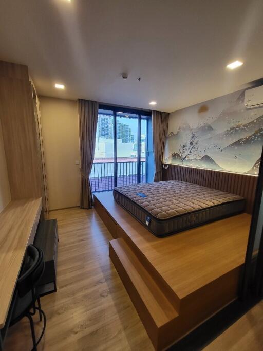 Spacious bedroom with a large window and balcony access