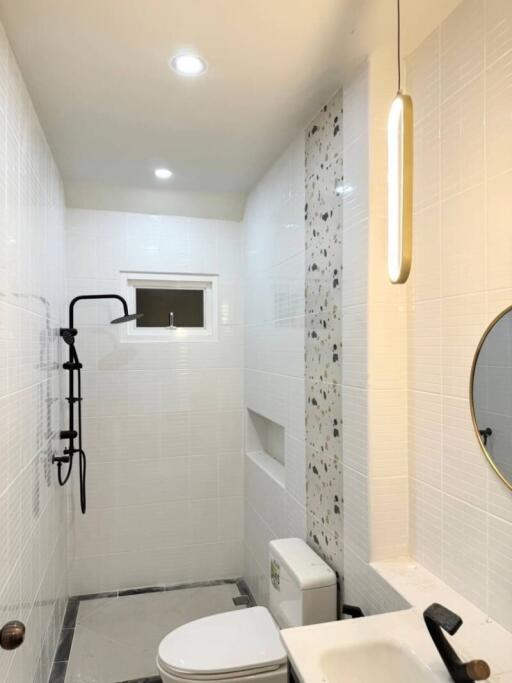 Modern bathroom with sleek white tiles, black faucet, and round mirror