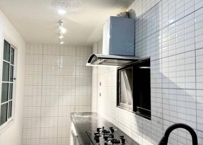 Modern kitchen with white tile backsplash and stainless steel appliances