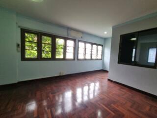 Spacious living room with large windows and polished wooden floor