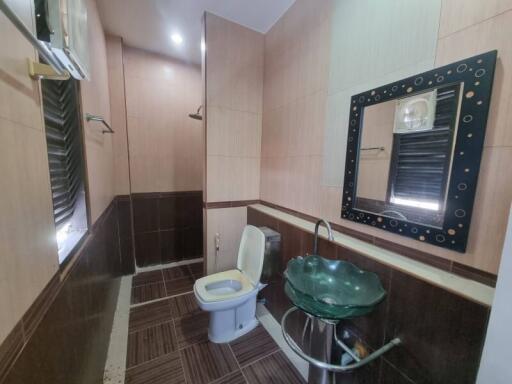 Modern bathroom with sink, toilet, and wall mirror