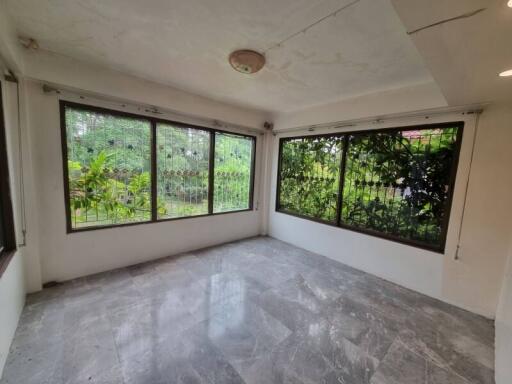 Bright sunroom with large windows and tiled floor