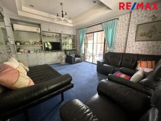 Living room with black leather sofas and blue carpet