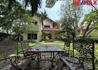 Outdoor seating area in a garden with a house in the background