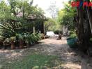 A lush garden space with potted plants and shaded seating area